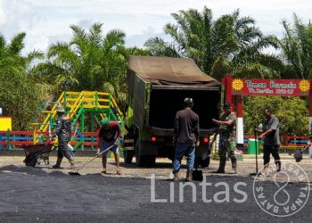 Koramil 21/Entikong melaksanakan kegiatan pengaspalan halaman depan TK KARTIKA XLVII