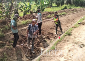 Babinsa Serda Bayu Arianto Bersama Warga Gotong Royong Bersihkan Lening Saluran Air Irigasi
