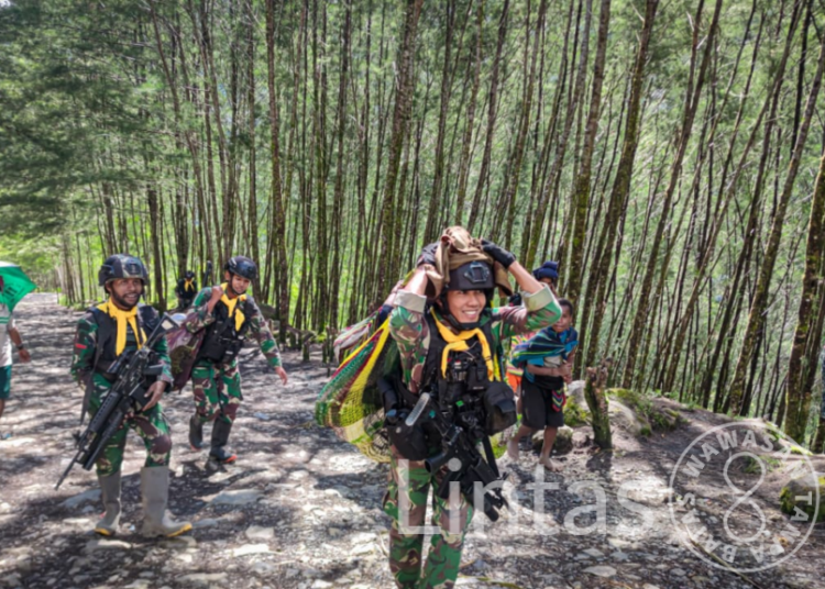 Satgas Mobile Raider 300 Siliwangi Bantu Membawa Barang Mama-Mama Papua
