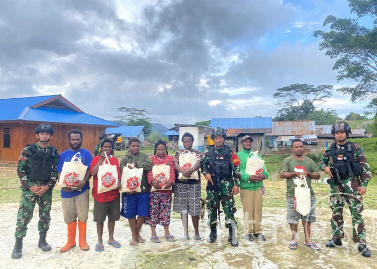 Nuansa Natal Yang Penuh Kasih, Satgas Yonif 310/KK Bagikan Sembako Untuk Warga Tulo Dan Kutdol