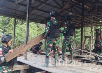 Peduli Kesulitan Masyarakat, Satgas Yonif 310/KK Bantu Bangun Rumah Warga