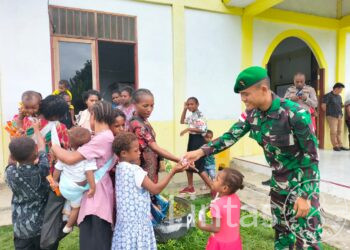 Keseruan Satgas Yonif 310/KK Bagikan Makanan Untuk Anak di Perbatasan Usai Ibadah Bersama