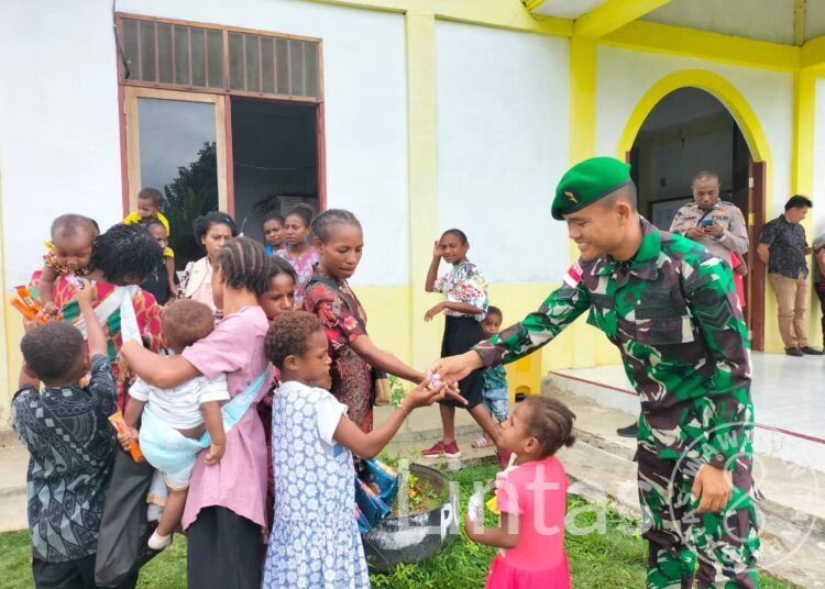 Keseruan Satgas Yonif 310/KK Bagikan Makanan Untuk Anak di Perbatasan Usai Ibadah Bersama