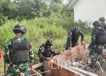 Satgas Yonif 310/KK Perbaiki Jembatan Sebagai Akses Menuju Pemukiman Warga