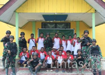 Lanjutkan Pembangunan Yang Lama Terhenti, Satgas Yonif 310/KK Pasang Keramik Lantai Gereja