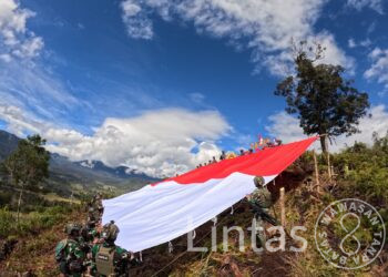 Satgas Yonif 323 Buaya Putih Kibarkan Bendera Raksasa di Atas Ketinggian Bukit Cakra Papua