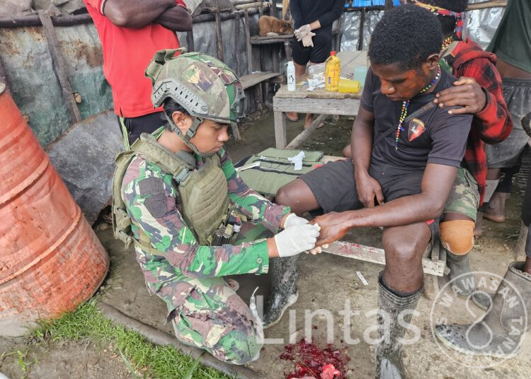 Satgas Yonif 323 Memberikan Pertolongan Pertama Masyarakat Yang Terluka Akibat Terkena Parang