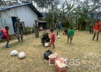 Satgas Yonif 323 Serahkan Bantuan Bola Kaki Untuk Anak-Anak Kampung Kago