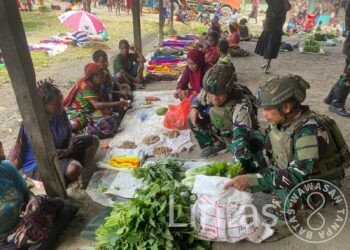 Personil Pos Sinak Satgas Yonif 700/WYC Belanja Hasil Tani Masyarakat di Pasar Sinak Mama Papua tersenyum Bahagia