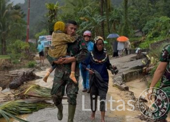 Serma Helmizon Babinsa Kapalo Koto BKO Yonif 133/YS Evakuasi Ibu dan Anak yang Terjebak Banjir di Pauh, Padang